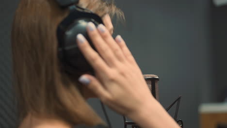 vocalist sings song with microphone in recording studio