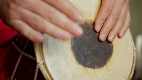 close up of hands of a man playing a drum.