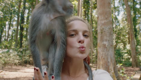 pov happy woman video chatting with monkey sitting on shoulder vlogger girl looking at camera filming travel adventure at zoo for wildlife vlog sharing experience on social media