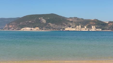 Farbkontrast-Von-Goldenem-Strand-Mit-Türkisfarbenem-Wasser-Mit-Bergen-Im-Hintergrund