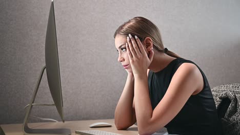 primer plano de una joven atractiva mirando atentamente y tensamente a la pantalla de la computadora en la oficina. mujer de negocios en el espacio abierto de coworking moderno