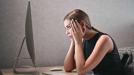 close-up of an attractive young woman looking attentively and tensely at the computer screen in the office. businesswoman in modern coworking open space