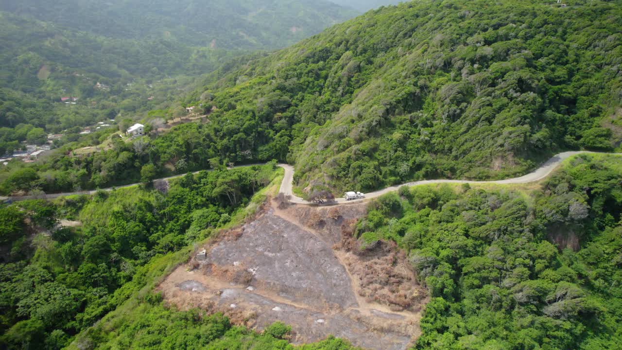 A cement truck drives through the mountainous road near the Caribbean Sea in La Guaira