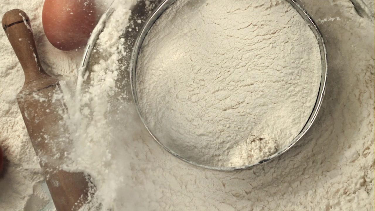 Mengayak Tepung dengan Bahan Kue di atas Meja
