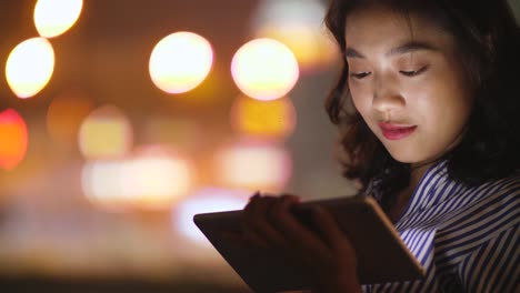 woman using tablet in cafe at night, 4k