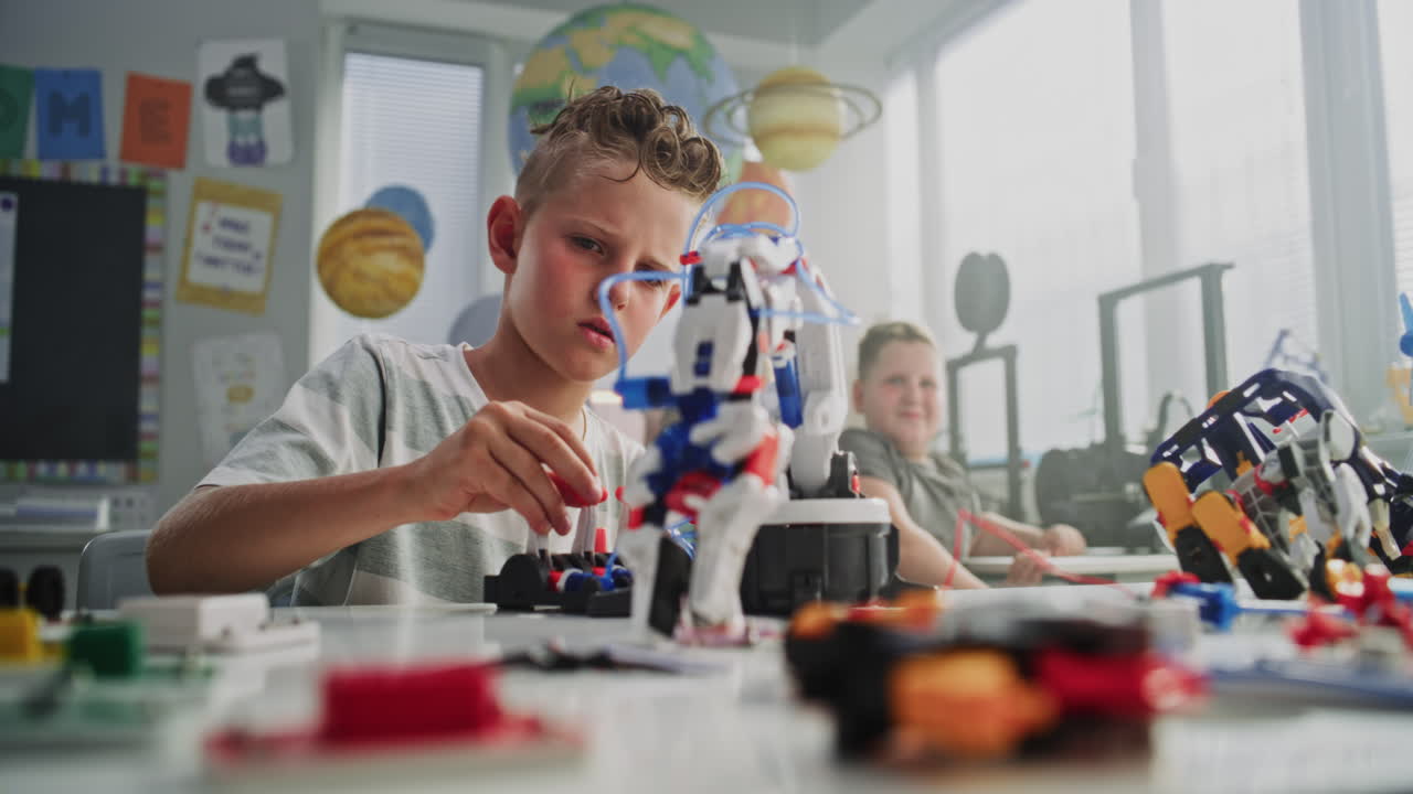 Elementary school boy wearing face mask sits safely in classroom looking at camera