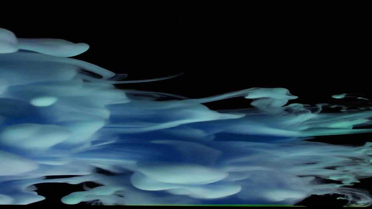 Inchiostro blu che turbina e si dissolve nell'acqua su sfondo nero