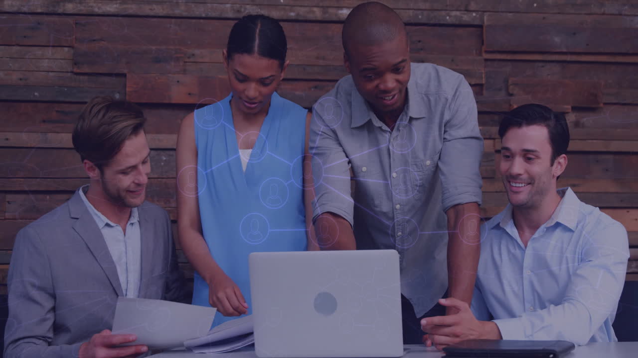 Diverse team collaborating over laptop with network connections animation overlay