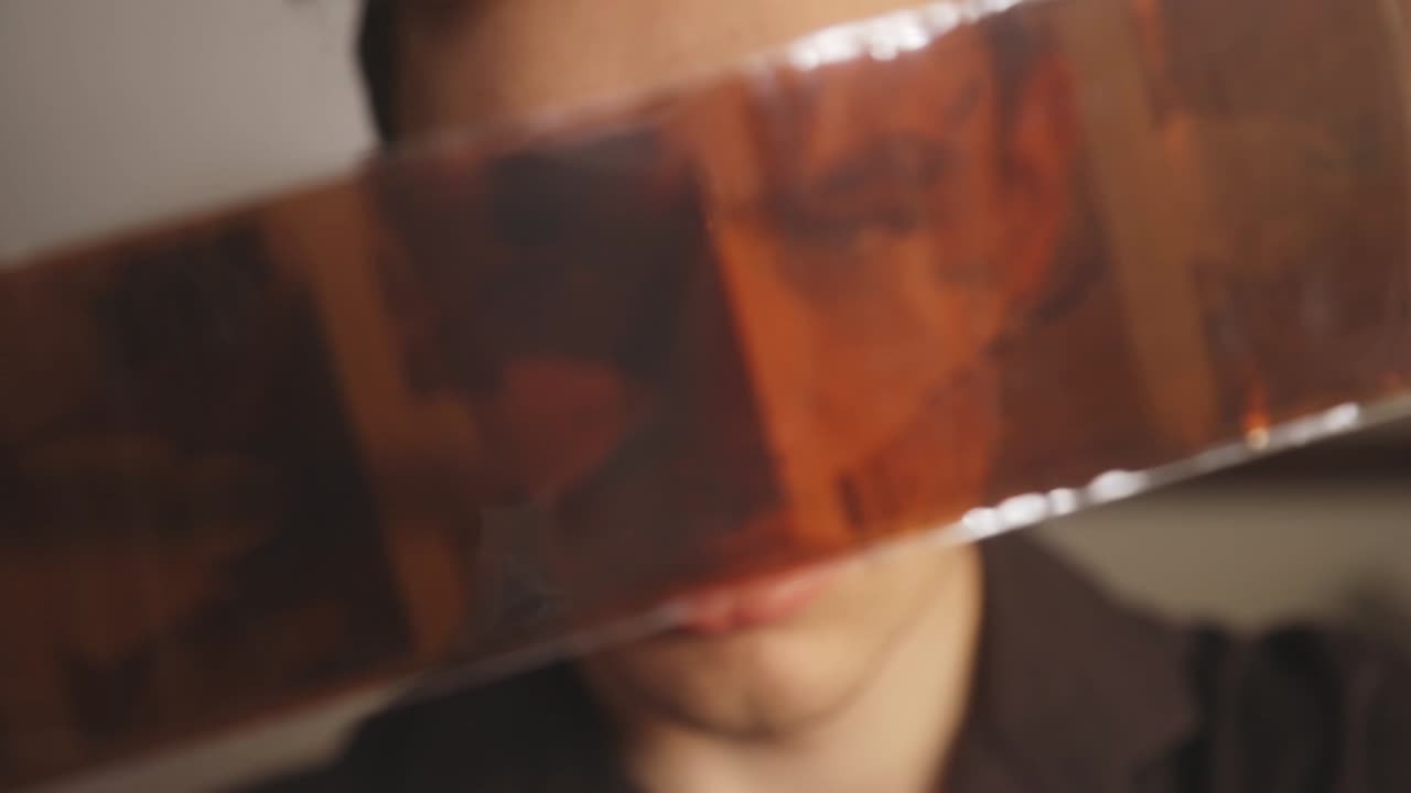 retrato de un hombre caucásico mirando negativos de película