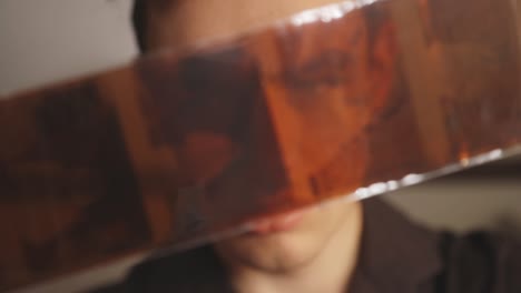 portrait of a caucasian man looking at film negatives