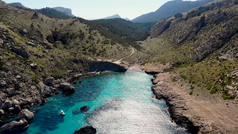 White-boat-floats-in-remote-cove-of-azure-Mediterranean