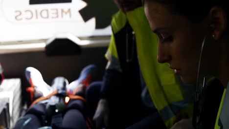 técnico médico de emergencia que lleva un coche a una mujer herida.