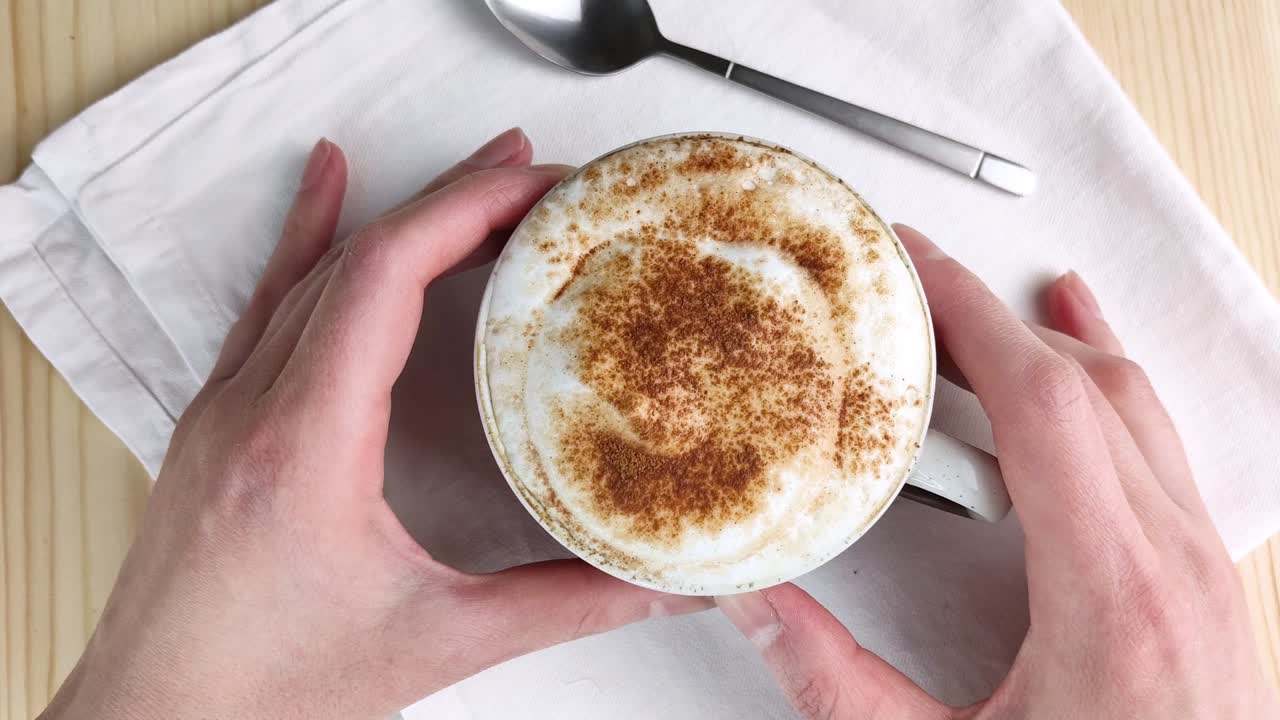 카푸치노 또는 라테. 두 손은 우유 거품으로 컵을 들고