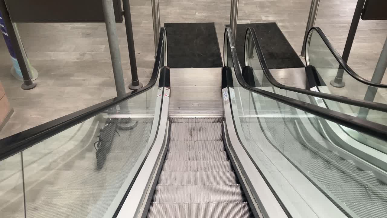 Frontperspektiv af rulletrappens trin, der bevæger sig opad i en kontinuerlig bevægelse. Ren urban indendørsscene, ideel til temaer som pendling, arkitektur og moderne transport.