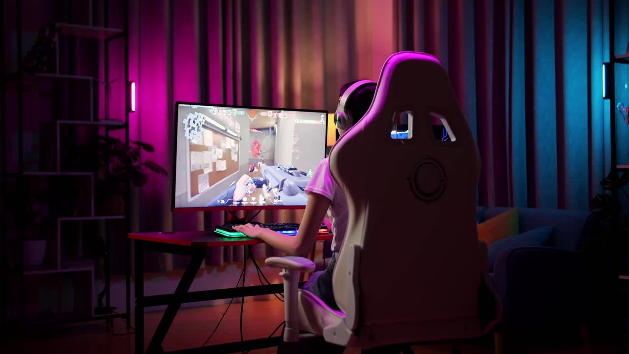 흥분 된 아시아 십대 소녀 게이머는 컴퓨터에서 비디오 게임을하는 동안 승리를 축하하고 춤을 추고 있습니다.