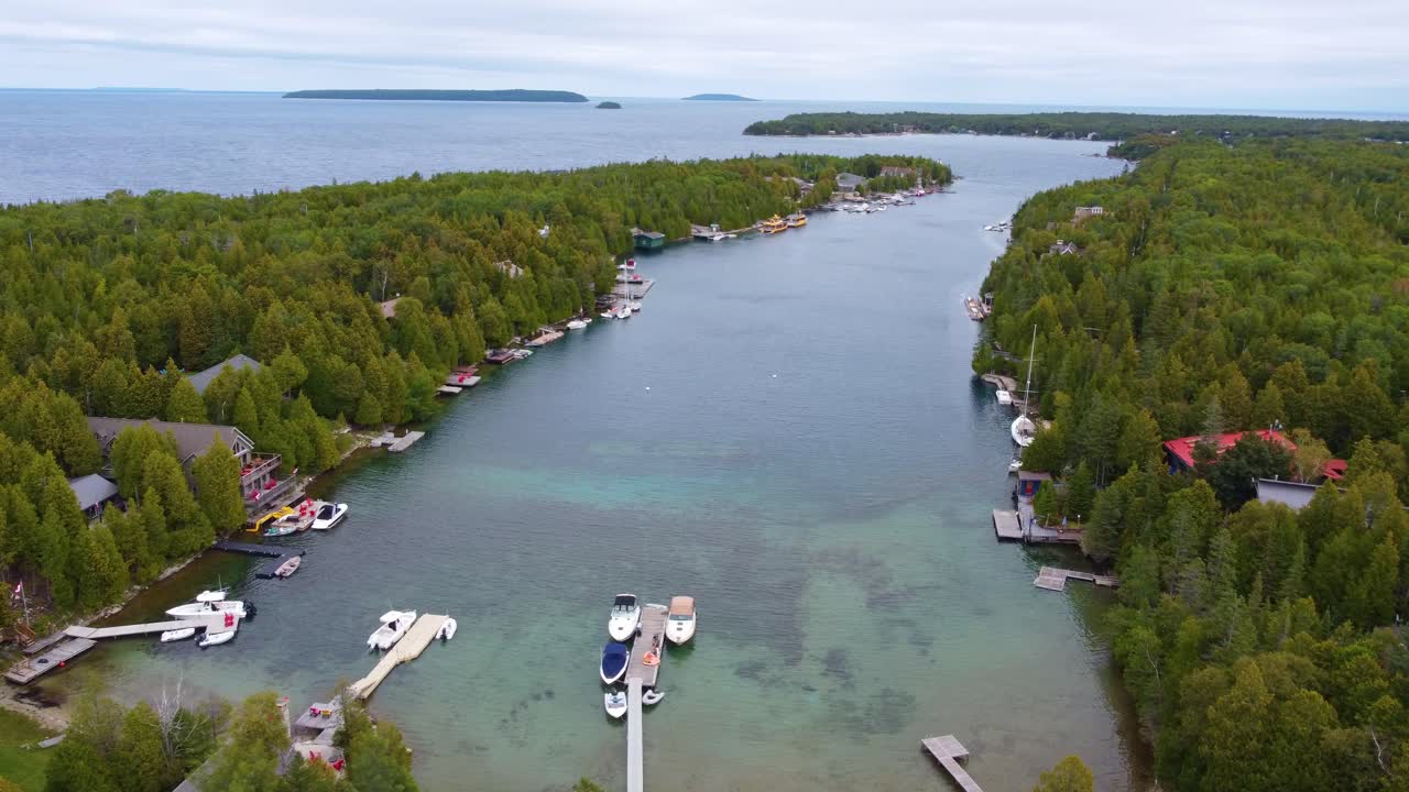 캐나다 온타리오 주 조지아 만 에 있는 밀집 한 소나무 숲 에 둘러싸인 오두막 과 보트 도크 의 공중 사진