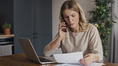 mujer caucásica con dificultades financieras y con una llamada telefónica.
