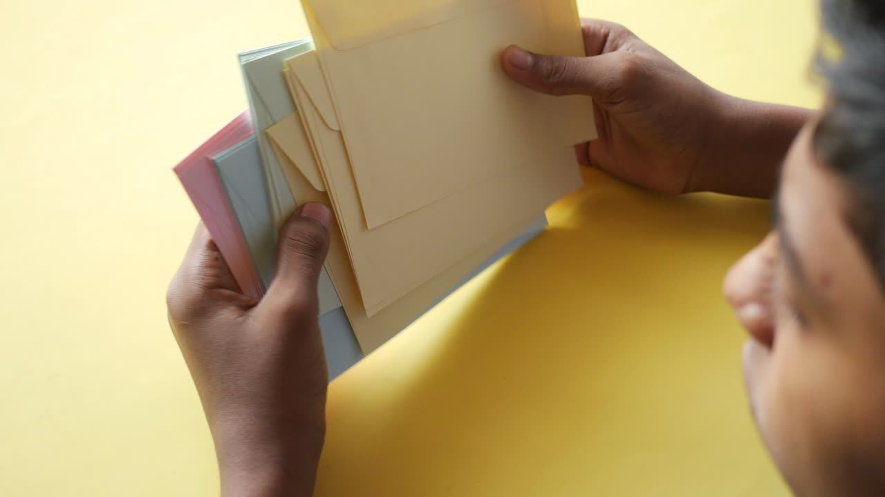 manos sosteniendo una pila de sobres de colores