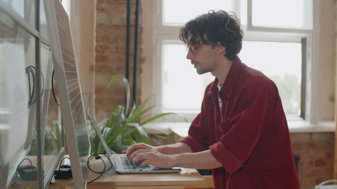 Businessman Charging Laptop with Solar Panel at Work in Office