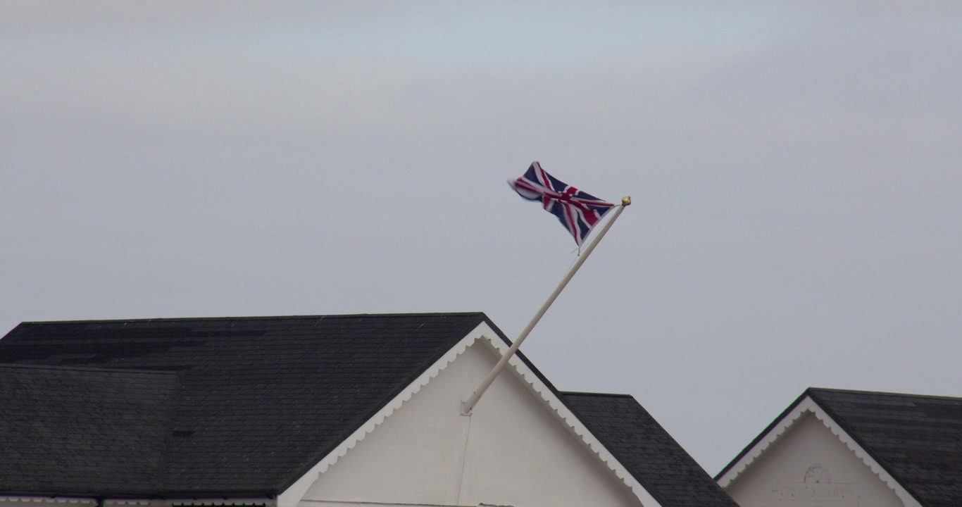 Union Jack-flagg som vaier på en veldig vindfull dag