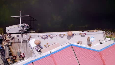 toma aérea de un restaurante soleado con vista general al mar, bonito bistró en la orilla al sol, al lado del océano