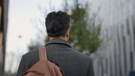 man walking in the city with a backpack