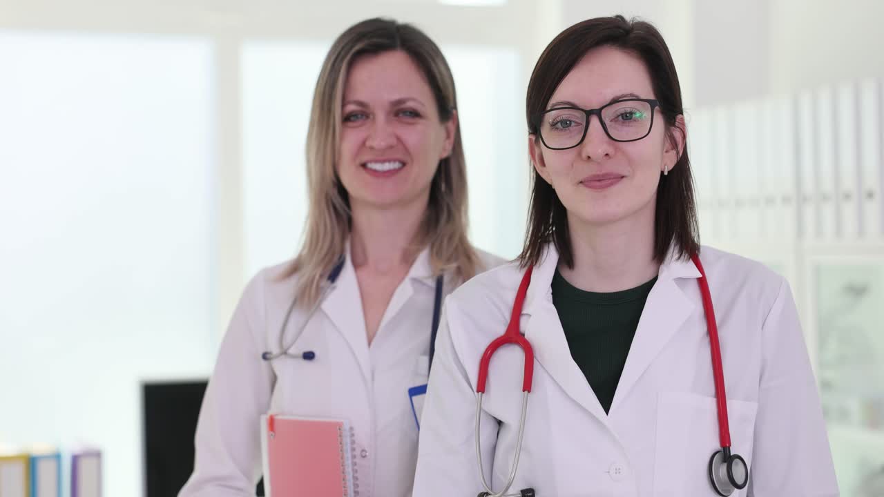 Two Female Doctors Give Thumbs Up in a Medical Setting