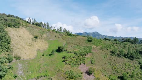 Aerial-revealing-shot-of-green-mountains-in-Bonao-during-sunny-day-on-Dominican-republic-Island