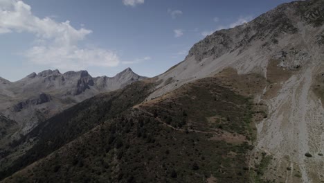 4k low-altitude drone shot over the western valleys natural park in the aragonese pyrenees, spain. a cinematic aerial view of the mountain trail leading to ibón de acherito.