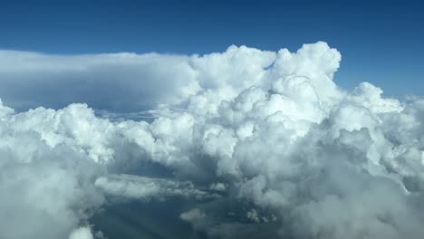 vista aérea tomada desde la cabina de un enorme cumuloninbus blanco durante el día a nivel de crucero