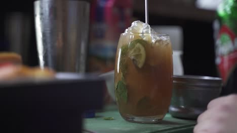 un barman profesional preparando un cóctel con hielo una mezcla de alcohol
