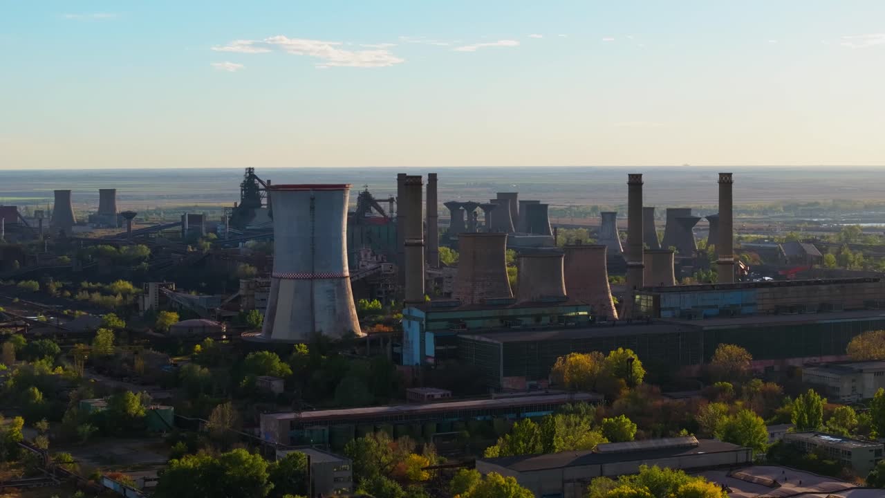 Aerial close up shot showing multiple towering smokestacks, clear sunny day with blue sky 4K50fps