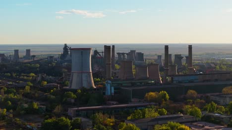 Aerial-close-up-shot-showing-multiple-towering-smokestacks,-clear-sunny-day-with-blue-sky-4K50fps