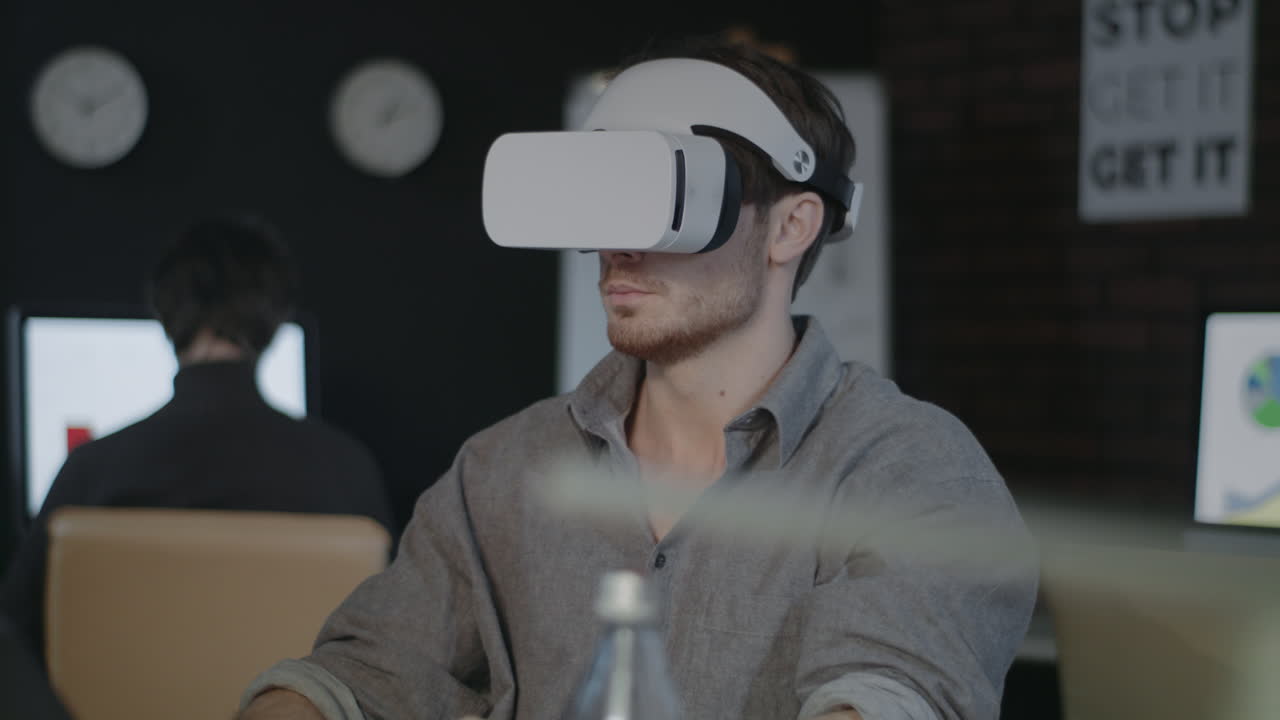 Game designer wearing VR headset and working in augmented reality in office