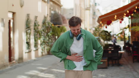 hombre turista sentimiento repentino fuerte dolor abdominal dolor de estómago diarrea gastritis problema en la calle de la ciudad