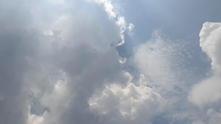 Blue summer sky with dense thick rain clouds moving across the heavens