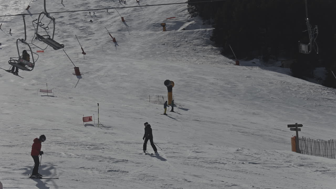 Skiers and Snowboarders Enjoying a Sunny Day on a Mountain Ski Slope