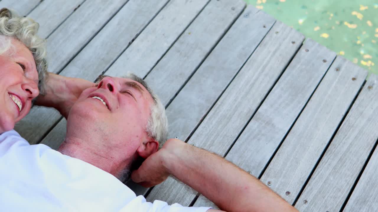 pareja mayor acostada en una tabla de madera 4k