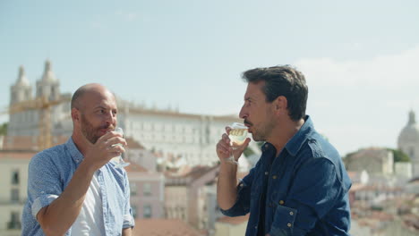 gays sentados en la torre de observación y bebiendo alcohol