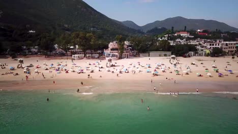 Eine-Sich-Parallel-Bewegende-Luftaufnahme-Von-Besuchern-Am-Shek-O-Beach-In-Hong-Kong-Als-öffentliche-Strände,-Die-Nach-Monaten-Der-Schließung-Inmitten-Des-Ausbruchs-Des-Coronavirus-Wieder-Für-Die-öffentlichkeit-Geöffnet-Werden