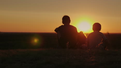 Zwei-Ländliche-Jungen-Spielen-Bei-Sonnenuntergang-Mit-Ihrem-Lieblingshund-1