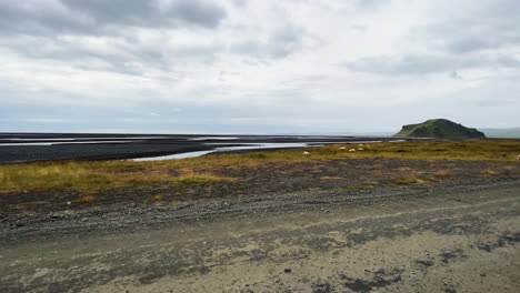 volcanic landscape in iceland with a mountain and vast plains from car