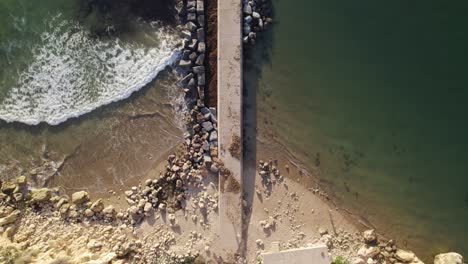 Toma-Aérea-De-Arriba-Hacia-Abajo-Del-Rompeolas-Del-Muelle-En-Ferragudo,-Portugal,-Aéreo