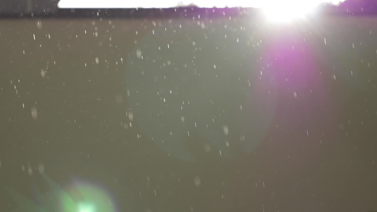 lluvia con sol y brillo de la lente cerca de la pared beige