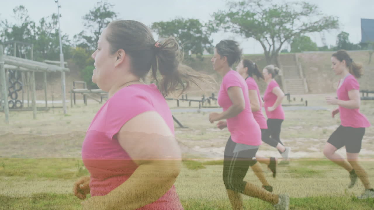 Jogging outdoors, women wearing pink shirts in group fitness session