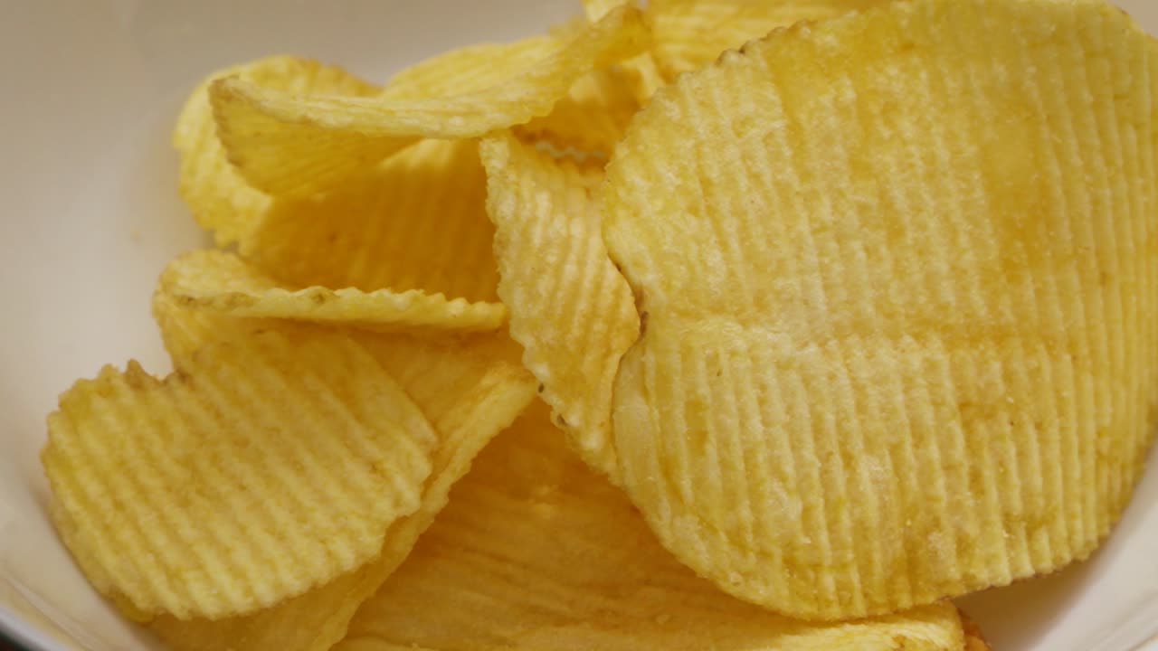 Potato Chips Crisps Falling into White Bowl in Slow Motion Ready for Friends Party Gathering - 4K Food Clip