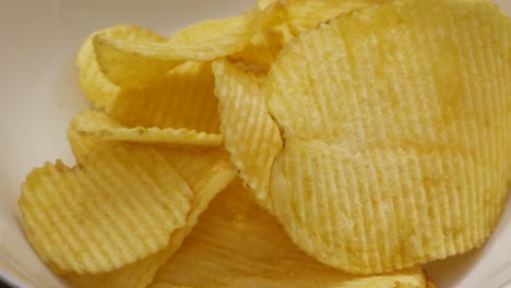 Potato-Chips-Crisps-Falling-into-White-Bowl-in-Slow-Motion-Ready-for-Friends-Party-Gathering---4K-Food-Clip