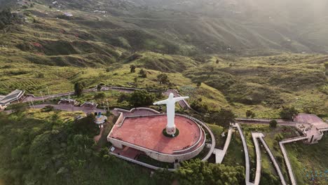 aerial view of christ the king monument in a mountainous landscape