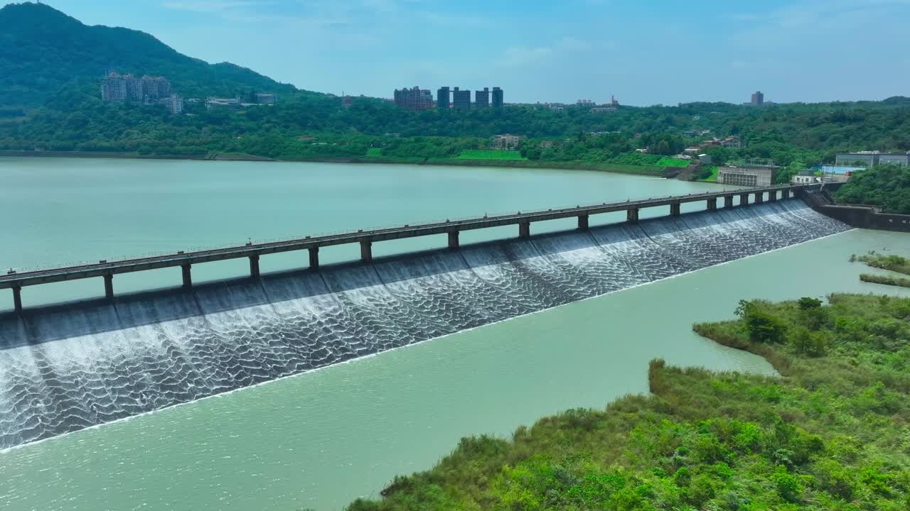 Aerial approaching shot of dam and lake in Taiwan during sunny day