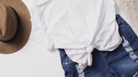 video de camiseta blanca, pantalones cortos de mezclilla, sombrero, bolso y espacio de copia sobre fondo blanco